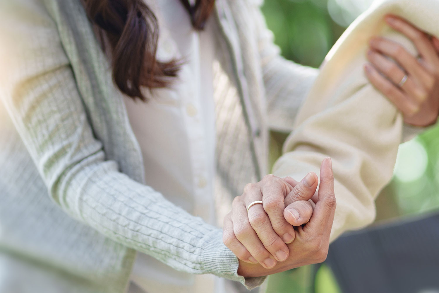 Eine ältere Person wird von einer Betreuerin gestützt